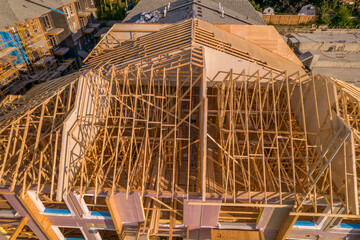 House construction and its wooden roof. Wooden housing. Timber frame house in North American downtown real estate.