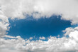 View of a piece of blue oval-shaped sky with white clouds at the edges of the frame, copy space.