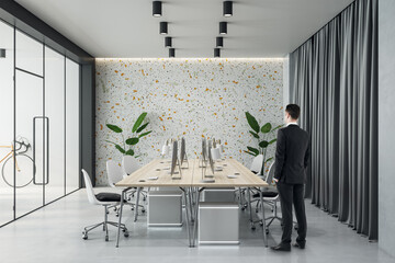 Aufkleber - Businessman back view in modern board room with light wooden conference table surrounded by chairs, green plants near multi colored wall and dark curtain