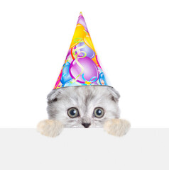 Canvas Print - Cute kitten wearing party cap looks above empty white banner. isolated on white background