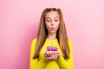 Poster - Photo of funky pretty school girl dressed yellow top blowing candle fire cake piece making wish isolated pink color background