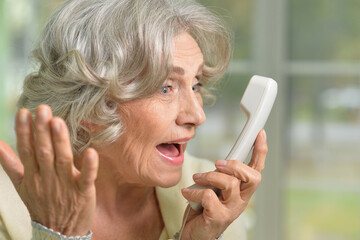 Wall Mural - Elderly woman holding her hand to her throat. Disease