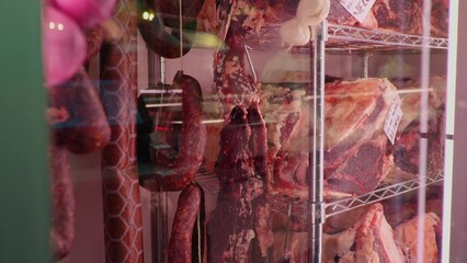 Wall Mural - Slices of dried beef meat along with types of sausages in dry ading cabinet. Dry-aged cuts of raw meat. Food manufactoring.