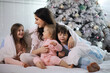© alexkich - A family with children having fun on the bed under the covers during the Christmas holidays.