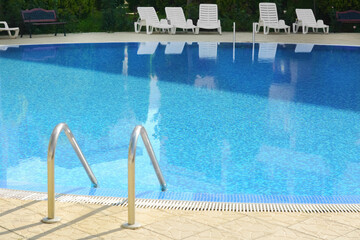 Poster - Outdoor swimming pool with ladder and handrails on sunny day