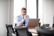© gzorgz - Shot of stressed businessman working with laptop at office
