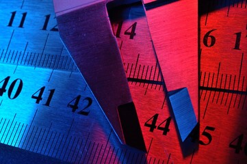 Wall Mural - caliper and metal rulers illuminated in red and blue. close-up