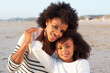 © KAMPUS - Portrait of pleased family on beach. Mother and daughter smiling, hugging, looking at camera. Family, love, bonding concept