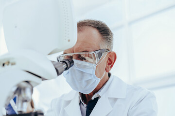 Wall Mural - close up. a serious scientist using a laboratory microscope.