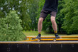 Close up of a skater wearing a shorts an jumping on a ramp at extreme sport competition outdoors.