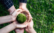 Top View Hands of People Embracing a Handmade Globe for Protecting Planet Together in World Earth Day Concept. Green Energy, ESG, Renewable, and Sustainable Resources. Environmental Care.