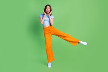 Sticker - Full length portrait of impressed cheerful person stand one leg cant believe isolated on green color background