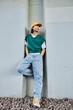 © Seventyfour - Vertical portrait of young Asian man wearing colorful street style clothes standing by concrete wall in urban setting