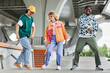 © Seventyfour - Full length portrait of young people wearing colorful street style clothes in urban city setting and dancing outdoors