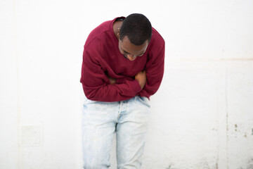 Wall Mural - Young african man looking down and smiling with arms crossed