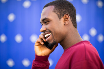 Wall Mural - Happy young african american man talking on cellphone