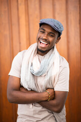 Wall Mural - Laughing young african american man with cap and scarf