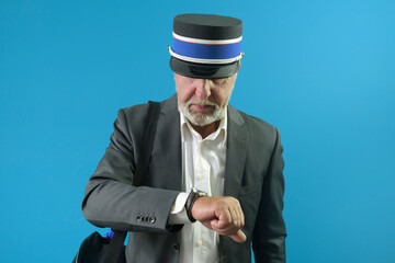 Wall Mural - The train conductor carefully looks at his wristwatch before the train leaves. On a blue background