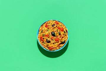 Wall Mural - Vegan pasta, spaghetti puttanesca, top view on a green background