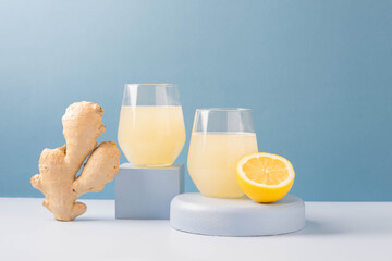 Poster - Antioxidant drink fresh ginger lemon in a glass trendy blue background, podium minimalism, balance