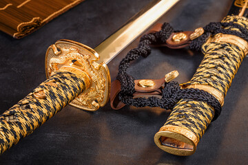 Japanese samurai katana sword and scabbard close up. Photo of a weapon in low key with selective focus