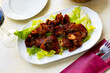 Toston cuchifrito, roasted suckling pig, dish of traditional cuisine of Extremadura region, served with lettuce salad