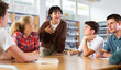 © JackF - Portrait of multi-ethnic group of teenage students chatting in college library with focus on smiling asian girl talking to friends