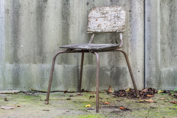 Wall Mural - Old damaged stool against a slate background. Rusty vintage outdoor chair.