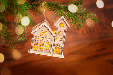 Wall Mural - christmas decoration in the form of a house on a spruce branch close-up with copy space