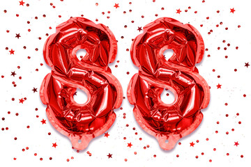 Wall Mural - The number of the balloon made of red foil, the number eighty-eight on a white background with sequins. Birthday greeting card with inscription 88. Numerical digit. Celebration event.