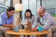 © jayzynism - Elderly friends building tower from wooden cubes leisure time in nursing home.