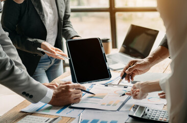 People using and looking at mockup laptop computer on wooden table together on office desk with clipping path tablet