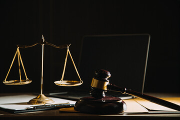 Business and lawyers discussing contract papers with brass scale on desk in office. Law, legal services, advice, justice and law concept picture with film grain effect