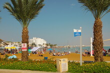Resort On The Dead Sea. Beach, Straw Umbrellas, Lifeguard Houses, People Bathe In Salt Water. Health Resort In Israel