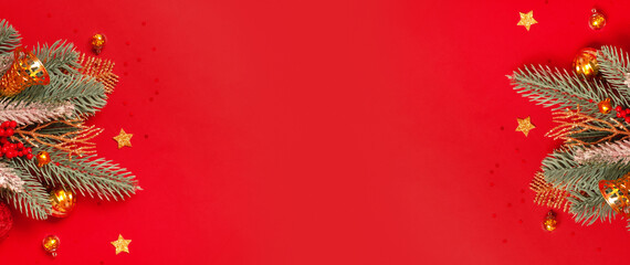 Wall Mural - Christmas decoration and pine tree on red background with copy space. New Year greeting card. Flat lay