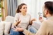 © dusanpetkovic1 - A nervous couple is arguing while sitting in living room at home.