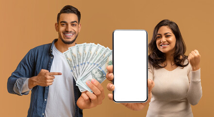 Overjoyed arab man and woman celebrating victory, showing smartphone, cash