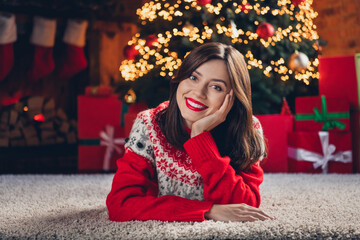 Poster - Photo of young woman happy positive charming smile hands touch cheeks dream lying floor rest weekend holiday inside house xmas tree decor indoors