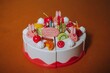 Vertical shot of a play food cake decorated with plastic fruit and smiling bunnies