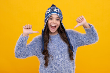 Modern teenage girl 12, 13, 14 year old wearing sweater and knitted hat on isolated yellow background. Excited face, cheerful emotions of teenager girl.