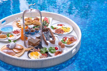 Breakfast in swimming pool, floating breakfast in villa resort. relaxing in calm pool water, healthy breakfast and tropical fruit.