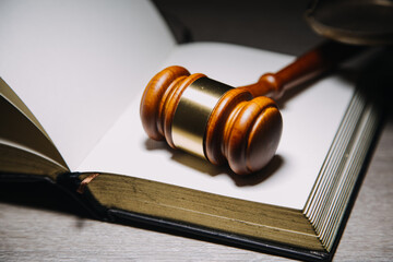 Justice and law concept.Male judge in a courtroom with the gavel, working with, computer and docking keyboard, eyeglasses, on table in morning light