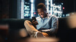 © Gorodenkoff - Excited Black African American Man Using Smartphone While Sitting on a Sofa in Living Room. Happy Man Smiling at Home and Chatting With Friends Over the Internet. Using Social Networks Concept.