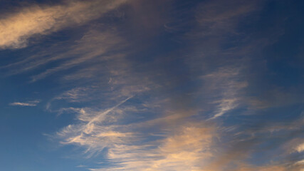 Wall Mural - blue sky with golden clouds beautifully illuminated by the sun as a natural background