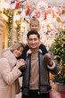 © ulianna19970 - happy family mom dad and baby daughter on Christmas fair in big city shopping mall close up photo on illuminated decorations