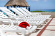 Santa Claus Hat on sunbed on caribbean sea background. Christmas and New Year vacation on the beach