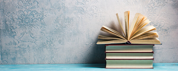 Vintage old hardback books, diary, fanned pages on wooden desk table and grunge background Daylight. Books stacking. Back to school. Copy Space. Education background.