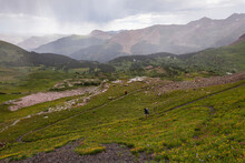 Two Small Hikers Descending A Pass Through A Storm On The Colorado Trail.