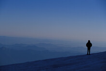 Man Standing On The Summit Of A Mountain.