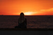© henryopzolder - Woman alone looking at the colorful sunset at La Caleta in Cadiz, Andalusia, Spain